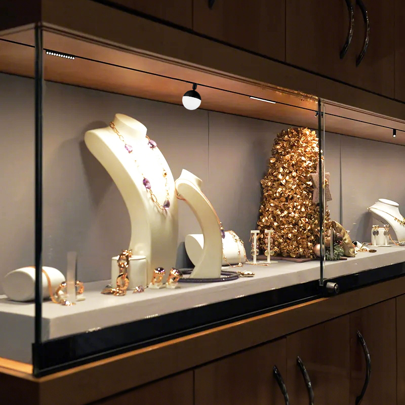 Magnetic LED track light illuminating jewelry display cabinet showroom