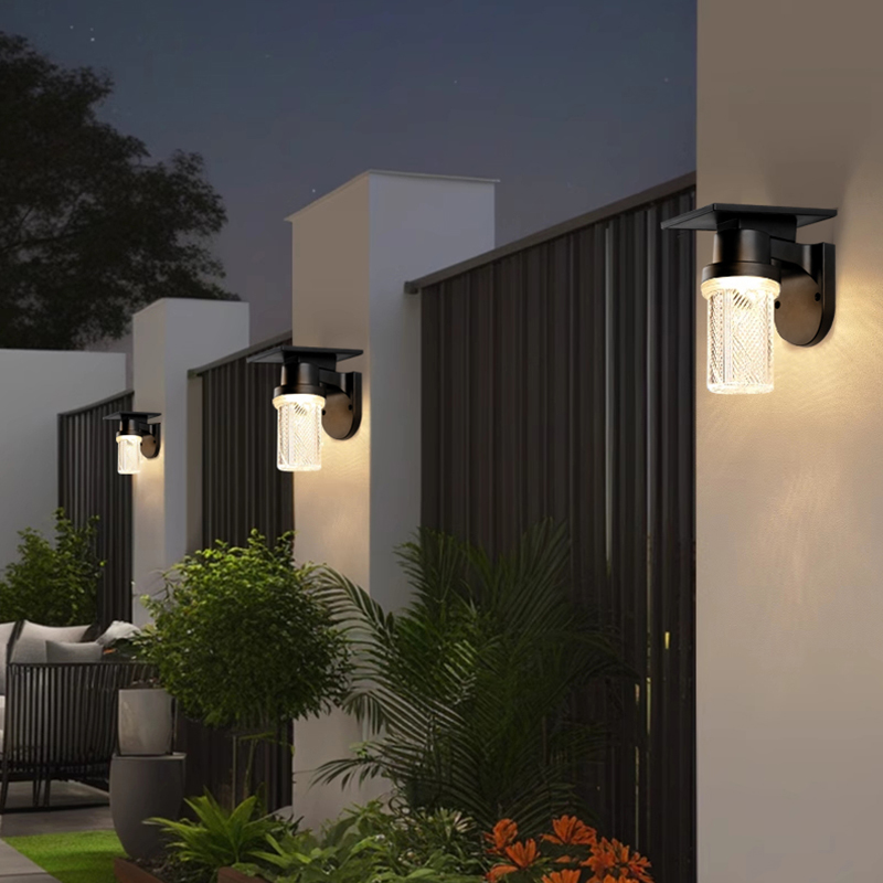 Solar powered outdoor wall light installed on garden fence post at night